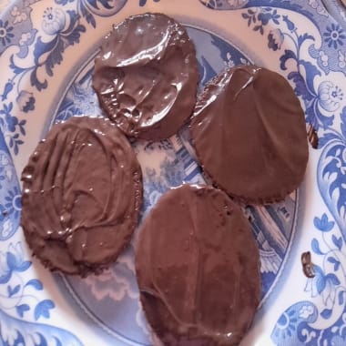 Four chocolate digestive biscuits on a blue flowered patterned plate